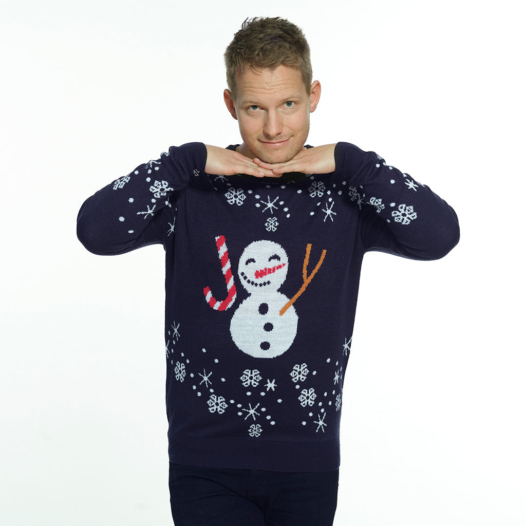 Un uomo che indossa un maglione natalizio blu con un pupazzo di neve e fiocchi di neve.
